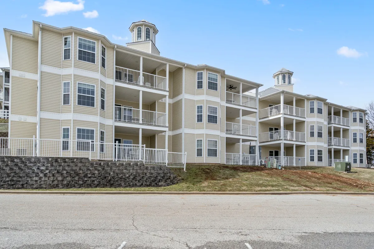 This image showcases the exterior of the property, highlighting inviting balconies and distinctive architectural details with a welcoming entrance. The scene suggests a connection between indoor living and the outdoors, ideal for guests who might enjoy dining or relaxing on the balcony with nature and lake views.
