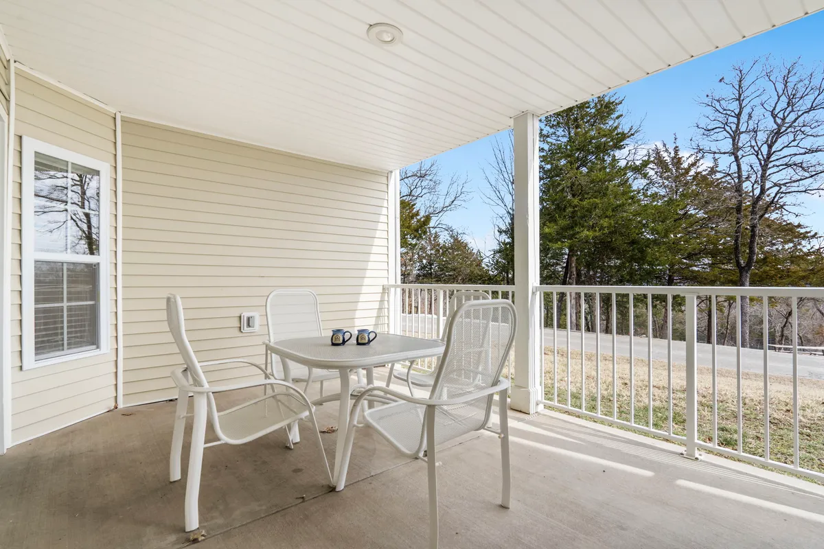 An outdoor deck area set with a table and two chairs, each with a coffee mug, overlooking a serene view. The setting is perfect for enjoying a morning coffee or unwinding in the evening, bringing the outdoors into daily living.