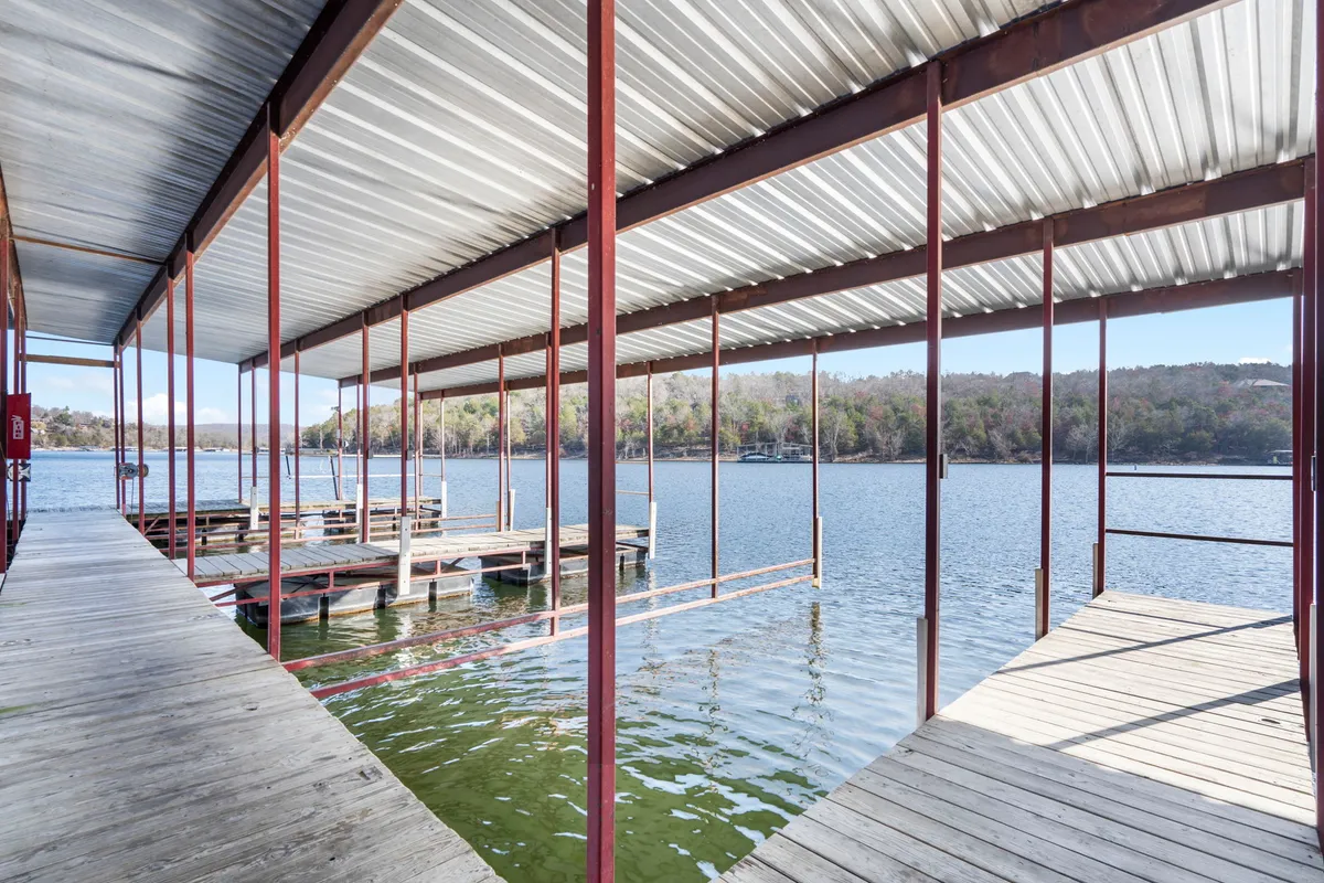 A peaceful wooden dock stretches over calm lake waters, surrounded by trees, inviting moments of lakeside leisure, fishing, or quiet reflection with one's pet.